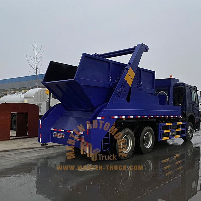 garbage truck picking up dumpster